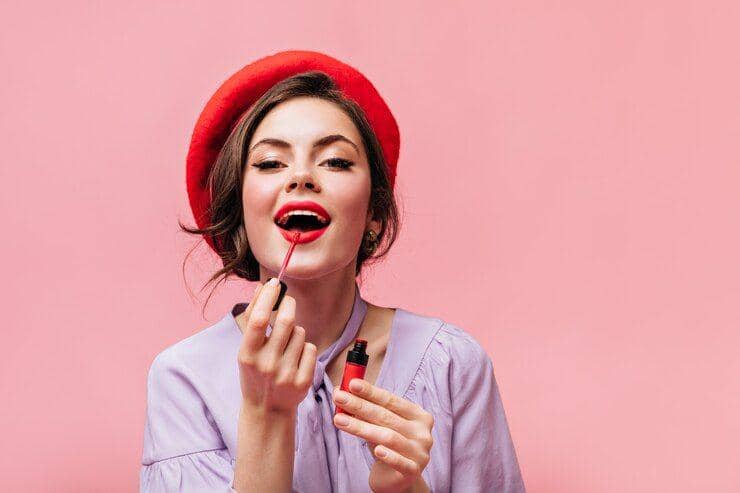 Ilustrasi perempuan memakai lip tint. (Freepik/lookstudio)