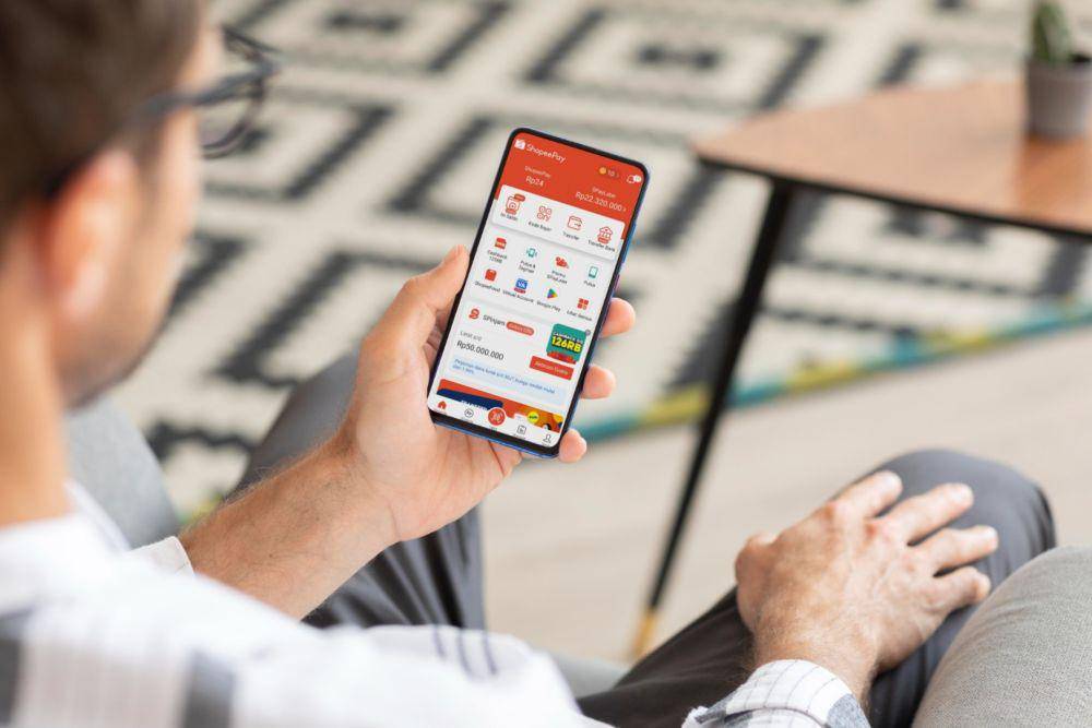 ilustrasi seorang pria sedang membuka aplikasi ShopeePay (Freepik.com/Freepik)