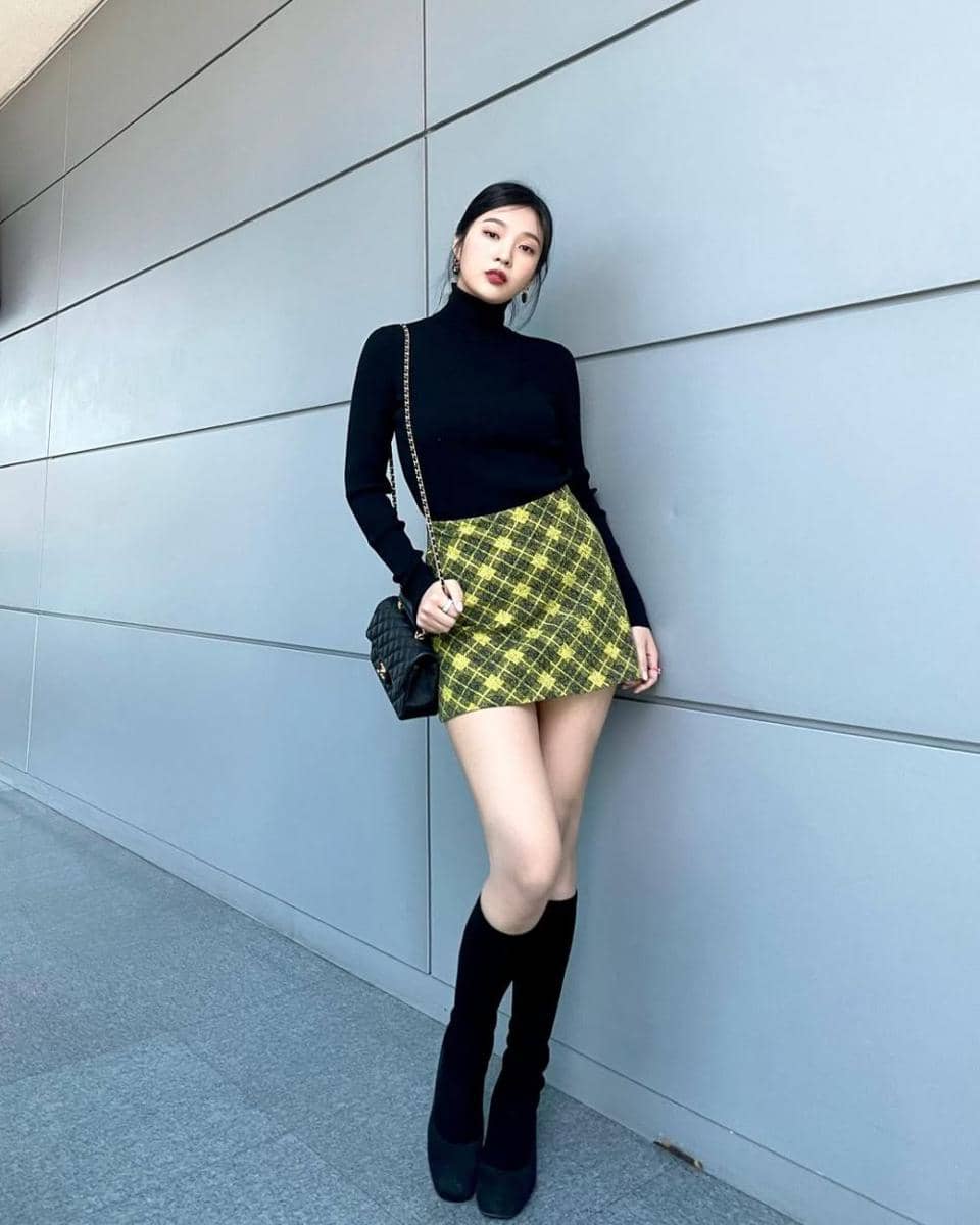 Joy memakai ribbed turtleneck dan tartan mini skirt