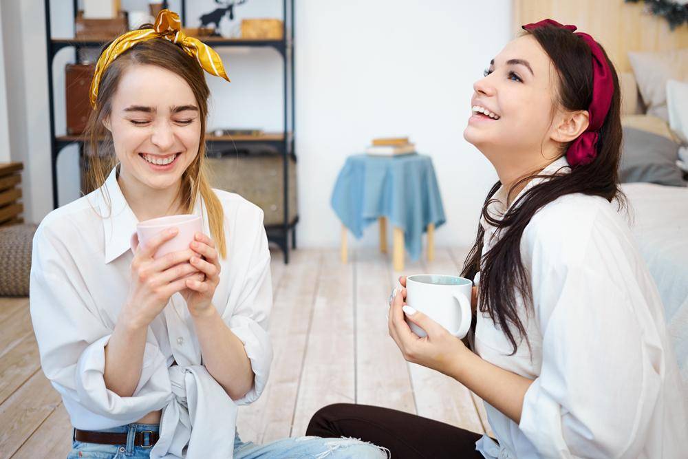 pretty-joyful-girls-having-fun-together-indoors-sitting-floor-with-mugs-coffee.jpg