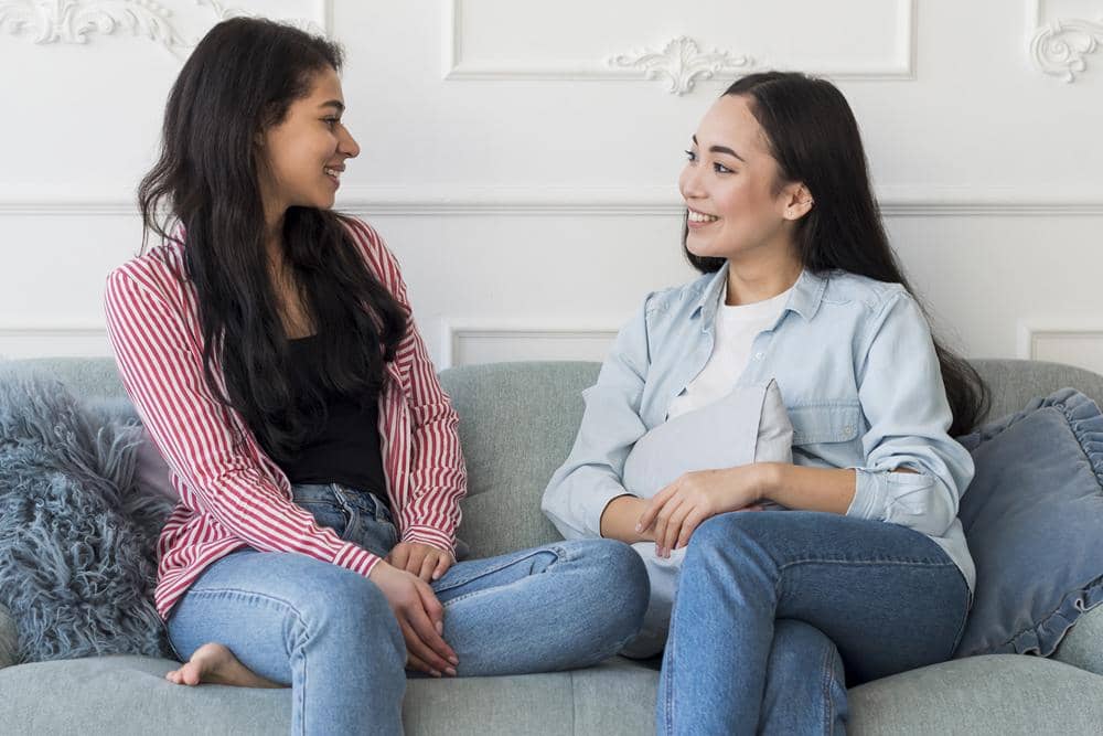 girlfriends-talking-while-sitting-sofa.jpg