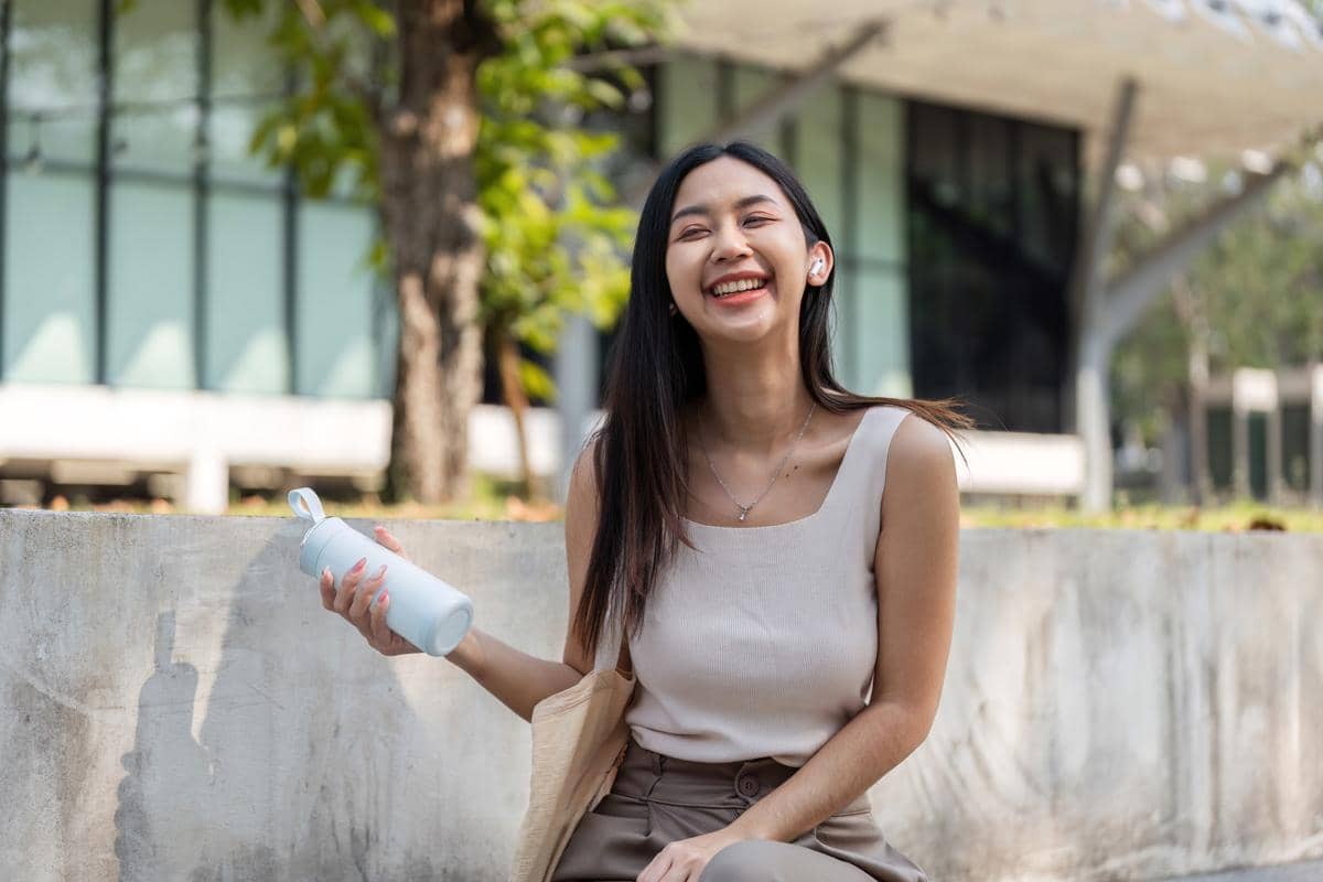 Ilustrasi seorang perempuan membawa tumbler.