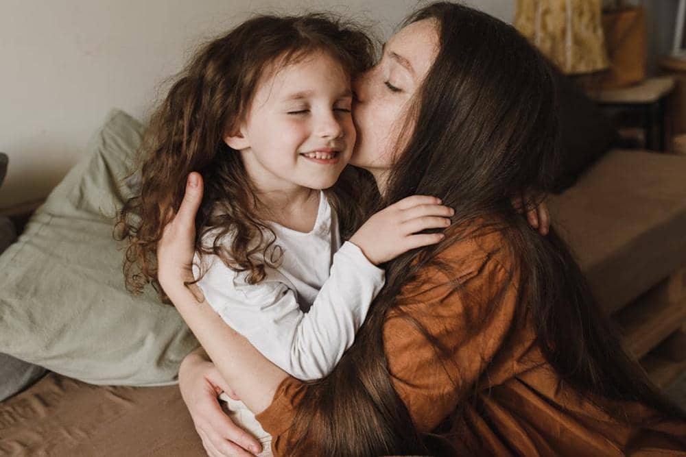 ibu mencium anak perempuannya