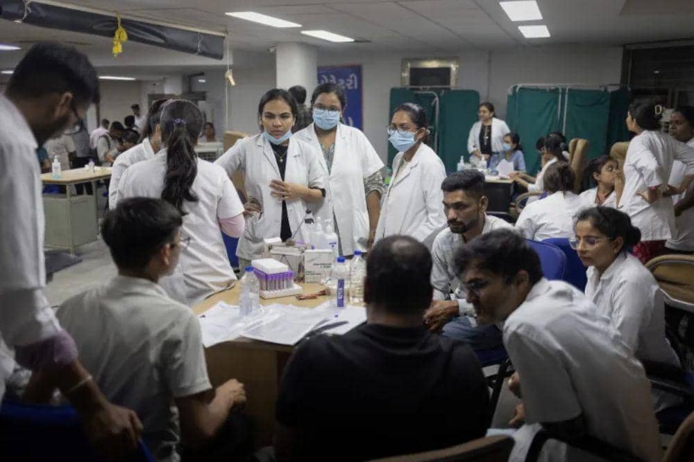 Tenaga kesehatan setempat menunggu untuk mengambil sampel DNA dari anggota keluarga korban (Dok. Reuters)