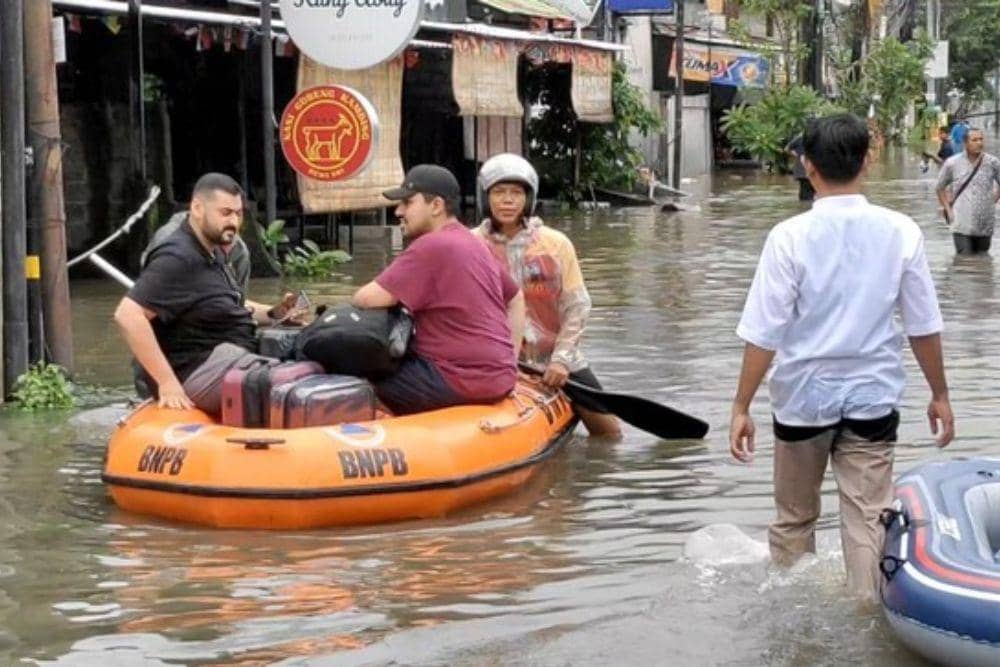 Turis dievakuasi memakai perahu karet saat banjir di Legian, Bali. (detikBali/Agus Eka)