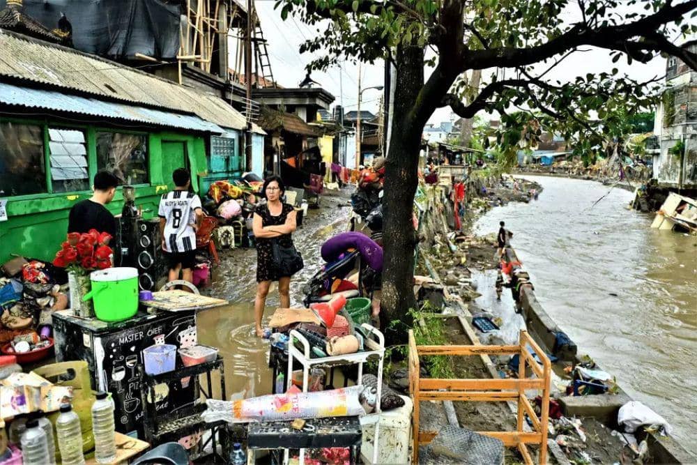 Warga melintasi permukiman yang terendam banjir di Jalan Bukit Barisan, Denpasar, Bali, Rabu (10/9/2025). (ANTARA Photo/Fikri Yusuf via jakartaglobe.com)