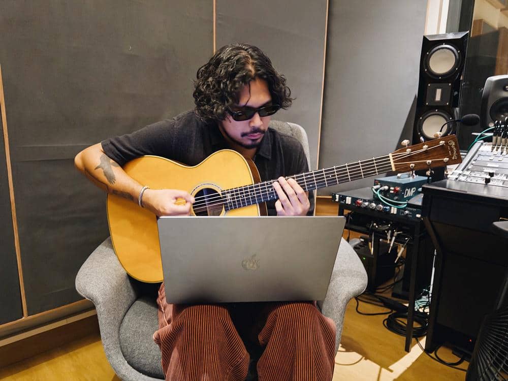 Petra Sihombing composing music with guitar and MacBook Pro M4 Max (1).JPG