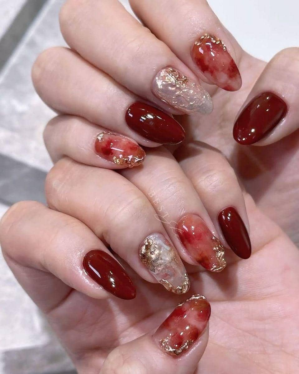 Nail art maroon dengan frame emas