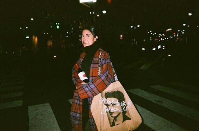 Gaya Sabrina Alatas mengunakan coat panjang motif plaid dengan scarf dan totebag