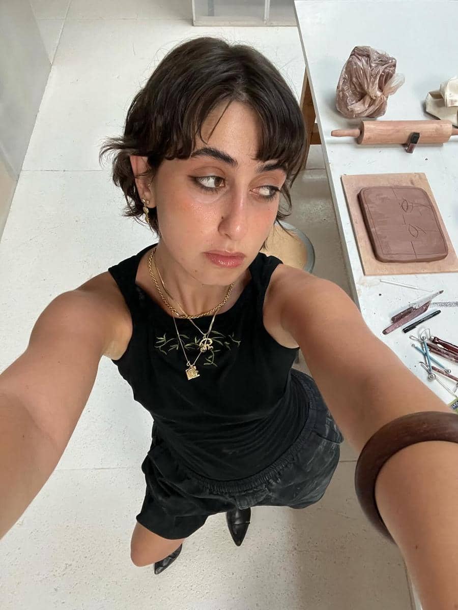 Rama Duwaji menggunakan kaos hitam, celana pendek dan pointed shoe