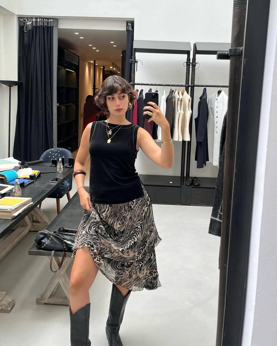 Rama Duwaji tampil kece mengkombinasikan sleeveless top bersama rok sifon motif hitam putih dan boots