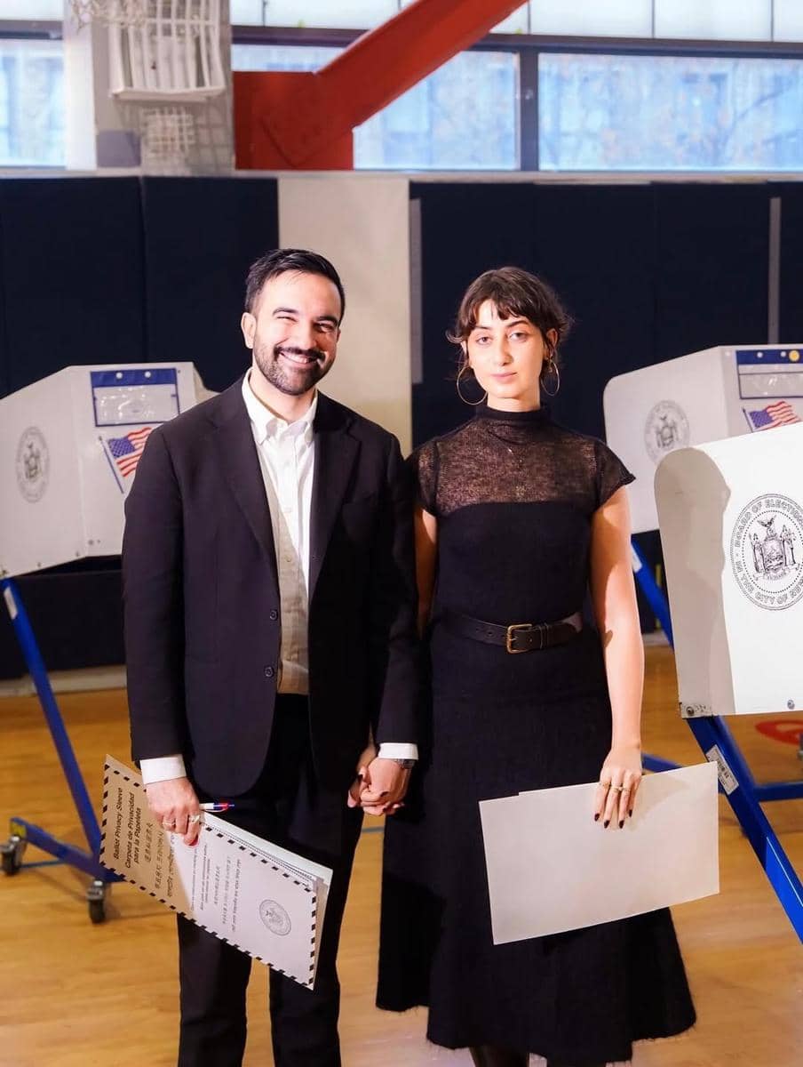 Rama Duwaji menggunakan mesh dress hitam yang dipadukan belt dan hoop earrings