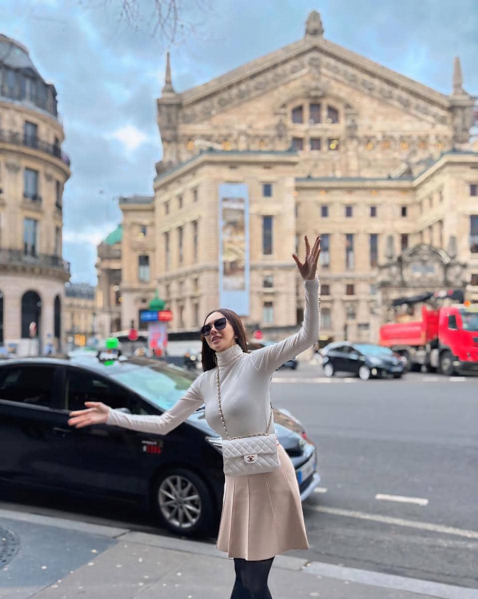 outfit aura kasih mengenakan turtle neck putih dipadukan rok pink muda