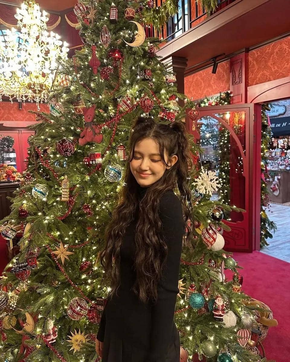 Danielle bergaya manis dengan dress hitam lengan panjang yang punya detail rok lipit