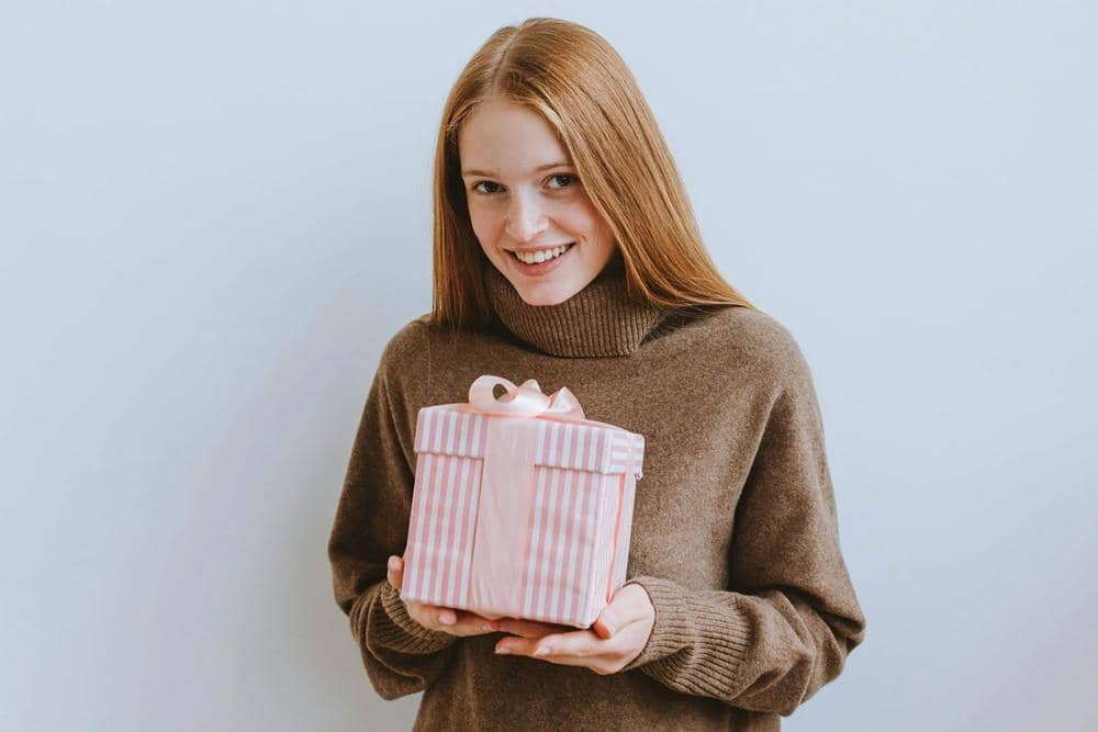ilustrasi perempuan memegang kado (pexels.com/Anastasia Shuraeva)