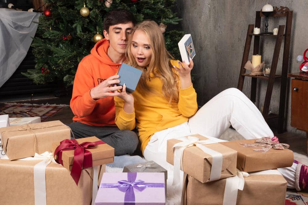 young-cute-couple-sitting-opening-presents-near-christmas-tree.jpg