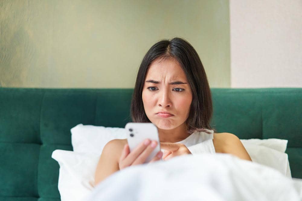 ilustrasi perempuan sedih sambil pegang hp (freepik.com/benzoix)