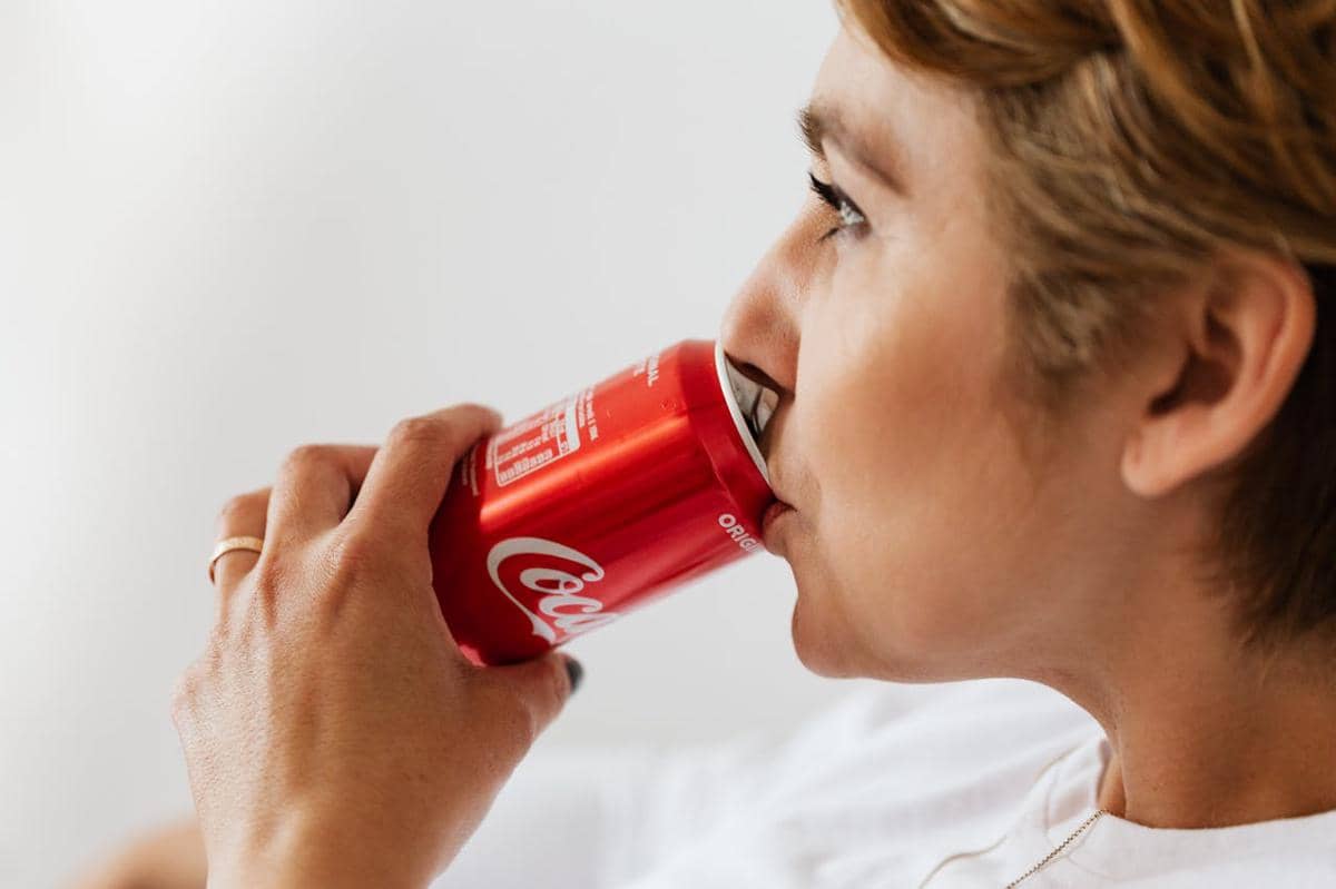 ilustrasi seorang wanita yang sedang minum soda