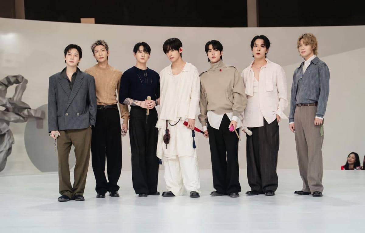 Ketujuh member BTS berdiri bersama di atas panggung saat konser ARIRANG World Tour.