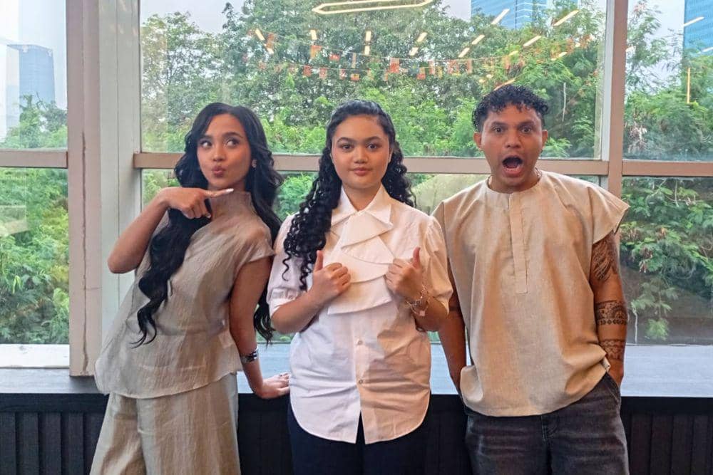 Lyodra, Amora Lemos, dan Silet Open Up berpose bersama di depan jendela besar dengan latar pepohonan dan gedung perkotaan.