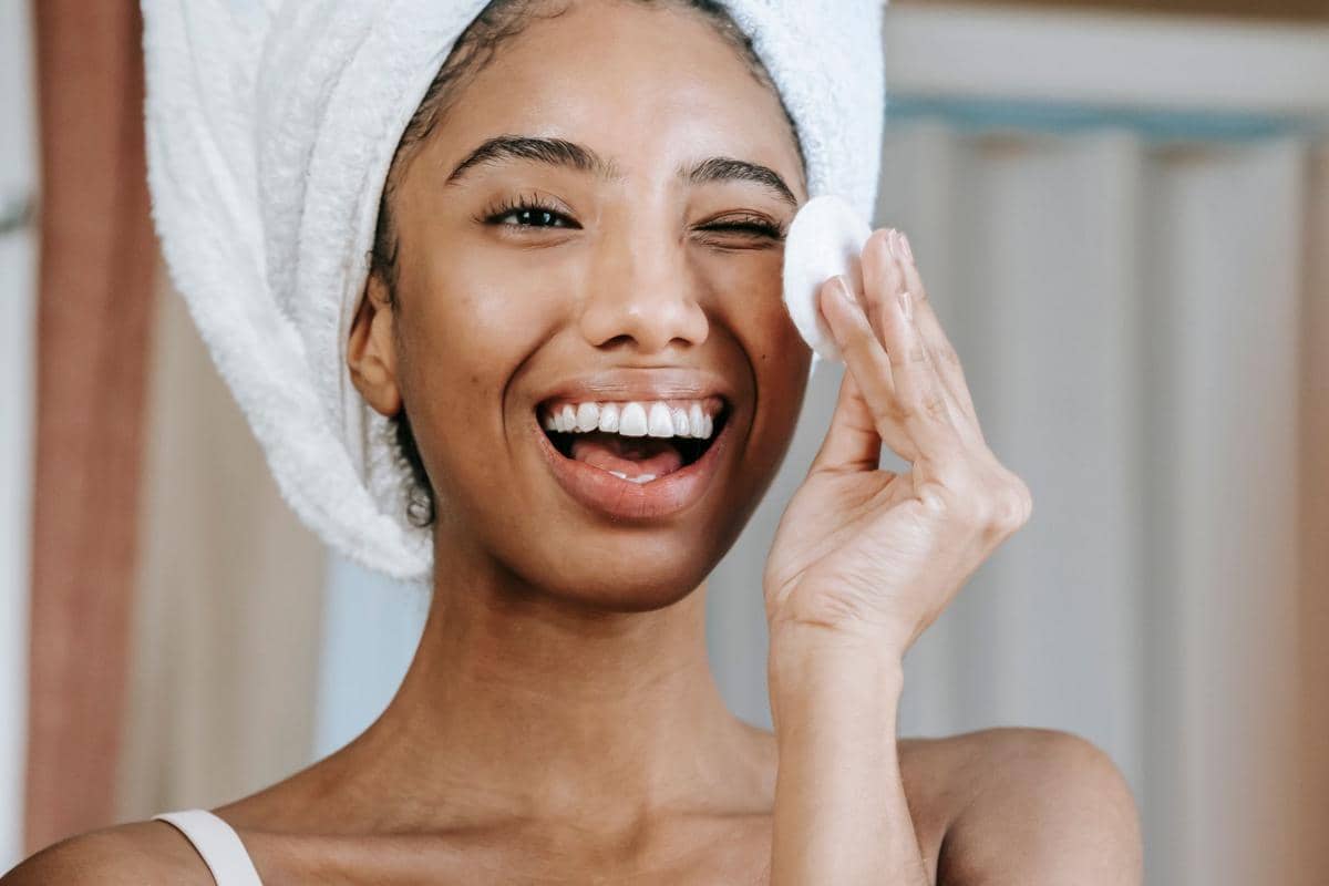 seorang wanita membersihkan wajah dengan cleansing 