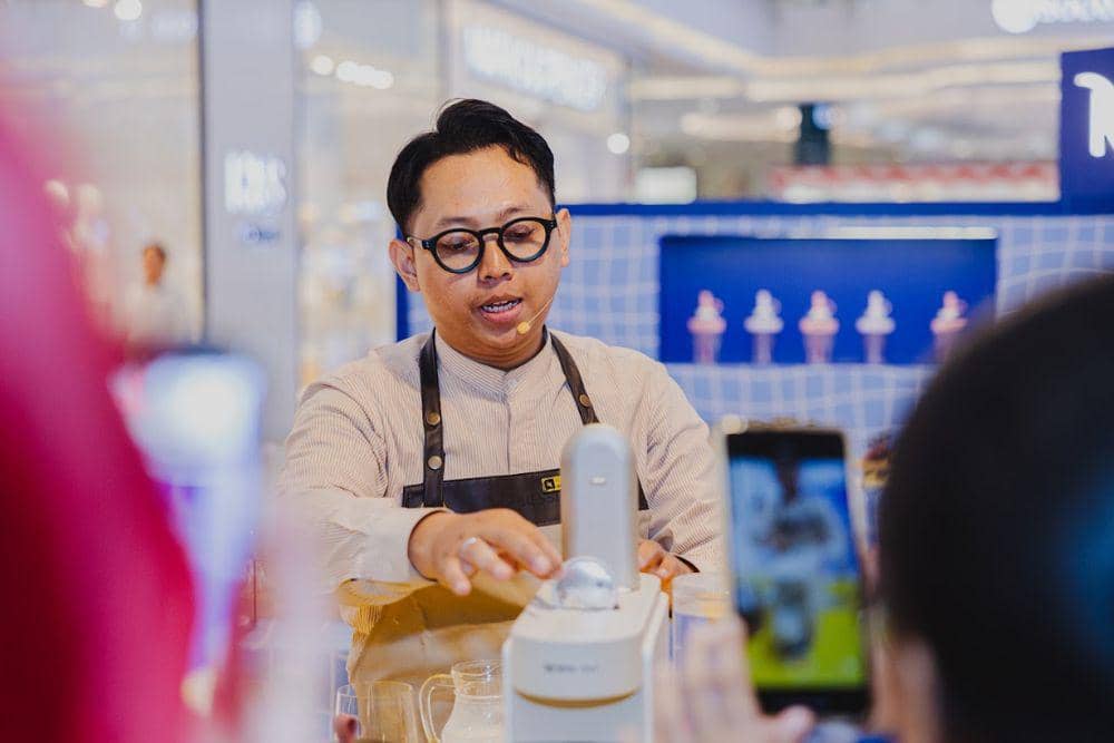Seorang peserta mencoba mesin kopi Nespresso Vertuo Up dengan pendampingan Coffee Specialist di area demonstrasi.