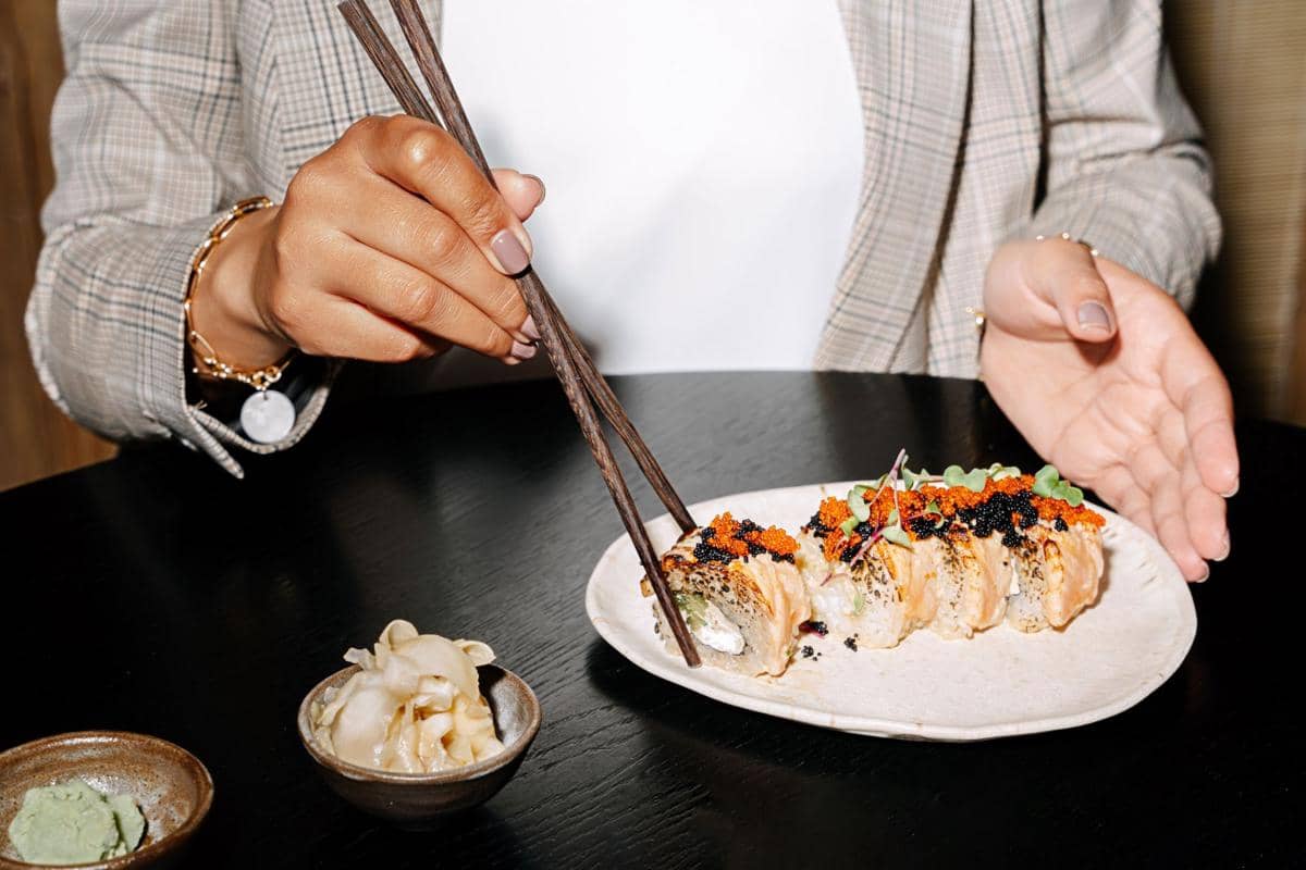 ilustrasi makan sushi menggunakan sumpit